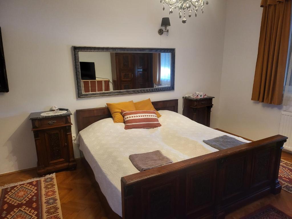 - une chambre avec un grand lit et un miroir dans l'établissement Káli medence kapuja 1, à Zánka
