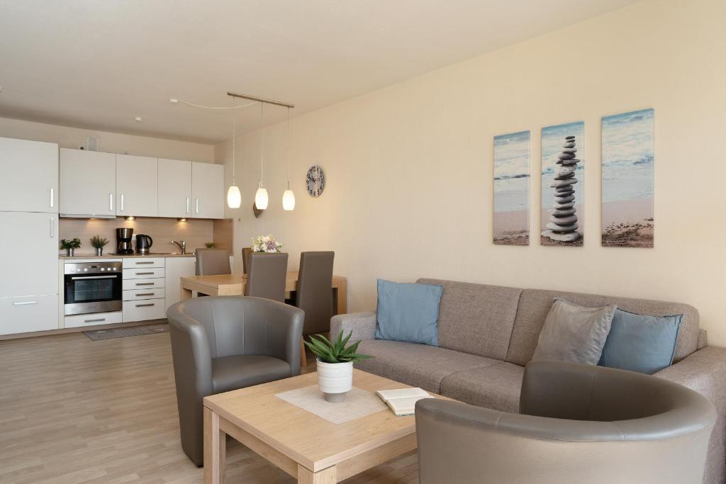 ein Wohnzimmer mit einem Sofa und einem Tisch in der Unterkunft Belvedere Ostseebrise in Grömitz