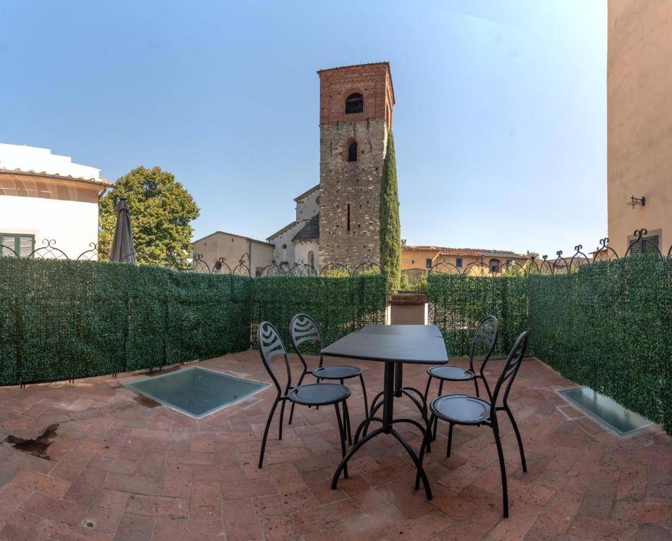 a table and chairs on a patio with a tower at Fabroniana Apartments in Pistoia