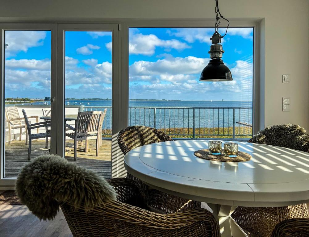 a table and chairs with a view of the ocean at Oceanhouse in Olpenitz