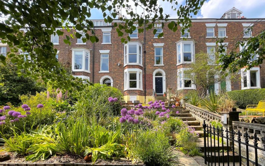 een tuin voor een groot bakstenen gebouw bij Deerness, 4star gold award 2024, Whitby in Whitby