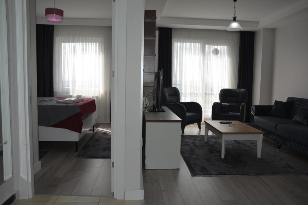 a living room and a bedroom with a couch and a table at Hera Emlak in Kırac