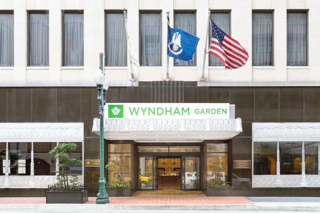 un edificio con dos banderas delante en Wyndham Garden Baronne Plaza, en Nueva Orleans