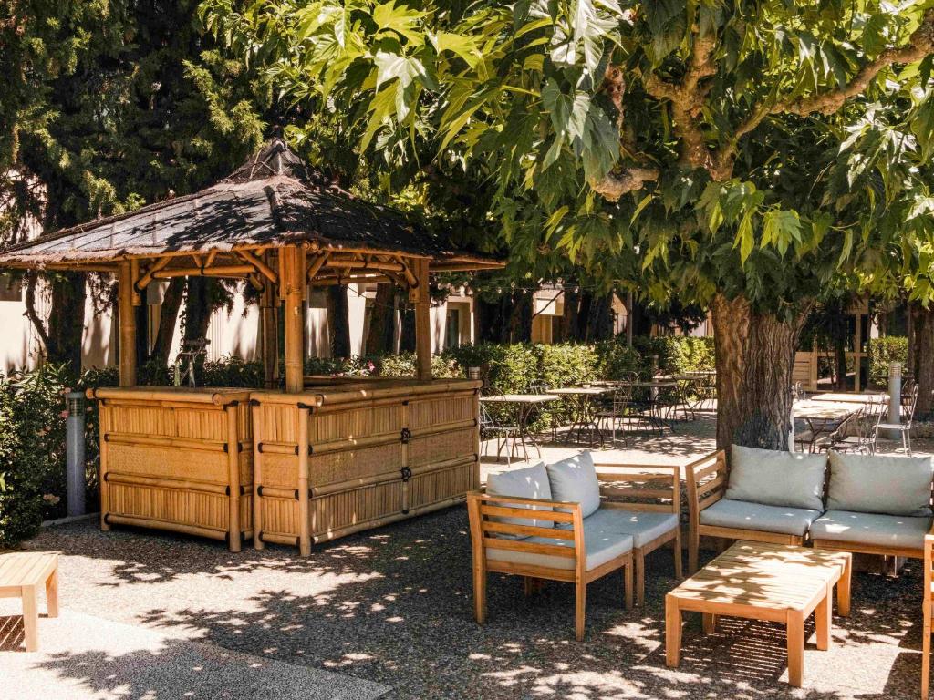 ibis Styles Avignon Sud في أفينيون: شرفة خشبية مع كراسي وطاولة