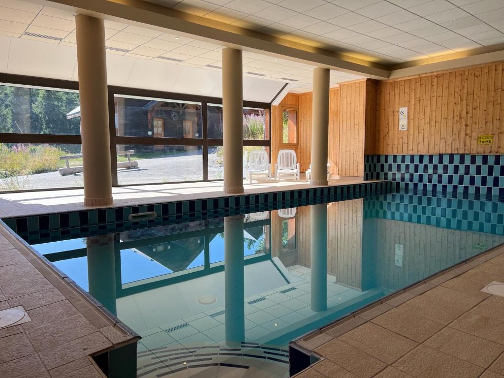 een zwembad in een gebouw met zuilen en een zwembad bij Pied des Pistes, 2 pièces, 6pers, Piscine et Sauna in Risoul