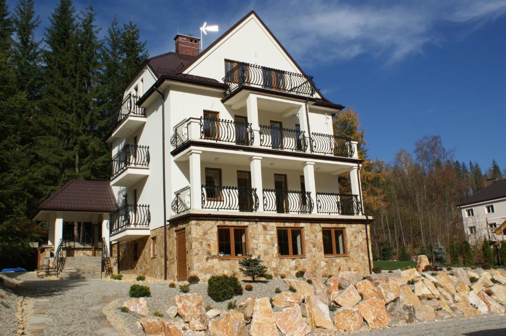 Una gran casa blanca con balcones en la parte superior. en Willa Ślązaczka en Wisła