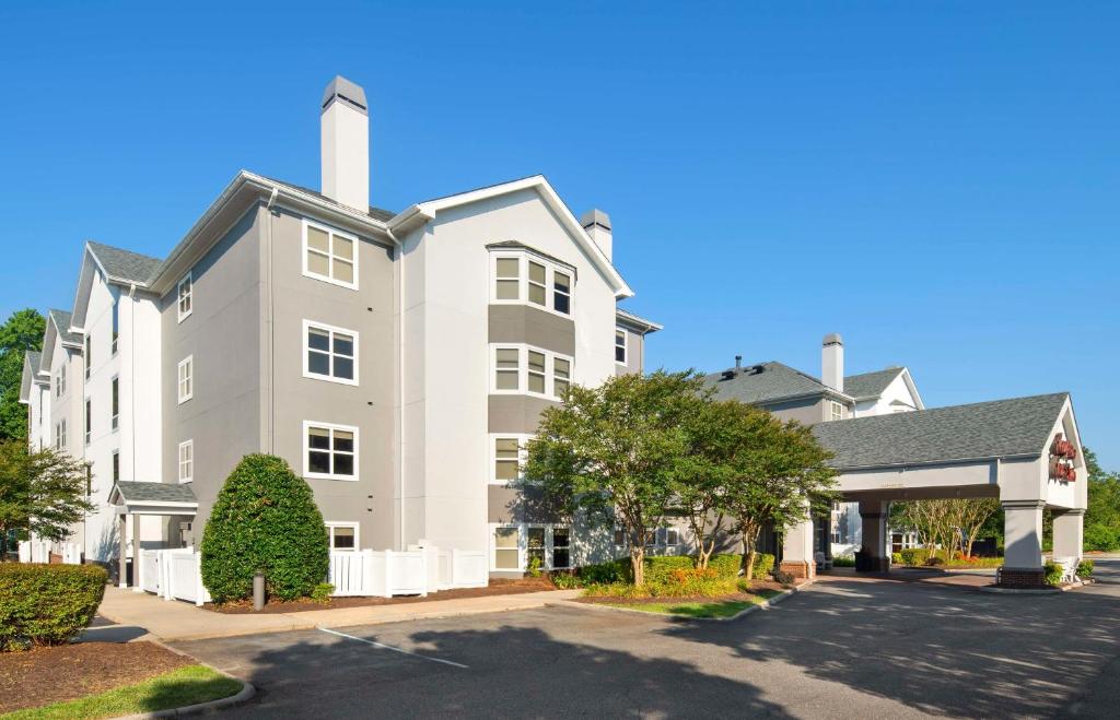 a large white building with a parking lot at Hampton Inn & Suites Newport News-Airport - Oyster Point Area in Newport News