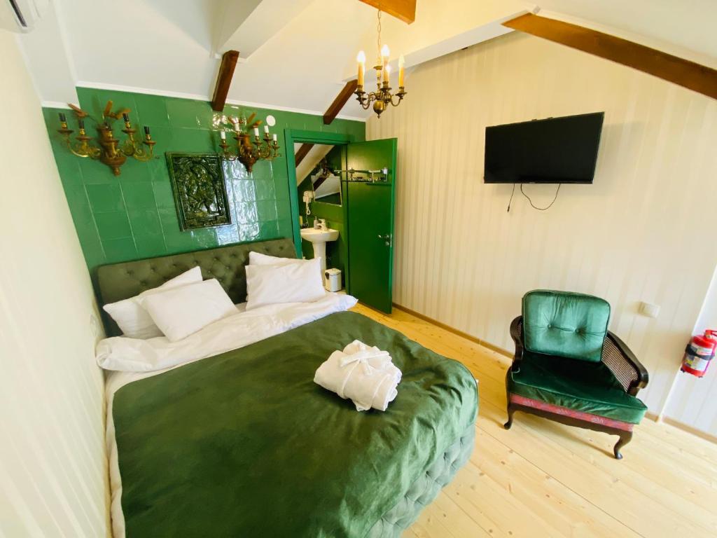 1 dormitorio con 1 cama verde y 1 silla verde en Tatin - Hotel & Café in Mtskheta en Mtskheta