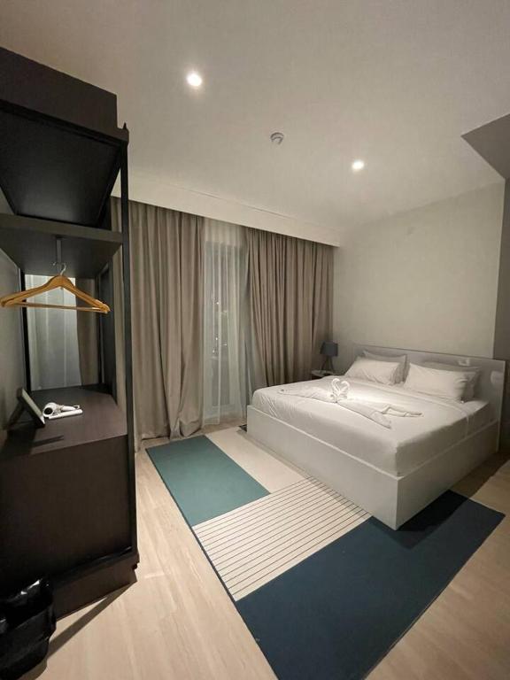 a bedroom with a large white bed and a window at Monde Residence K 01 Batam Centre in Nagoya