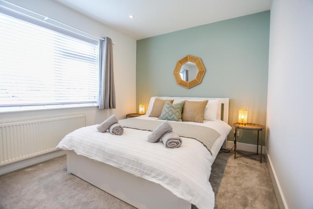 a bedroom with a large white bed and a window at Southern - Bracklesham Bay in Chichester