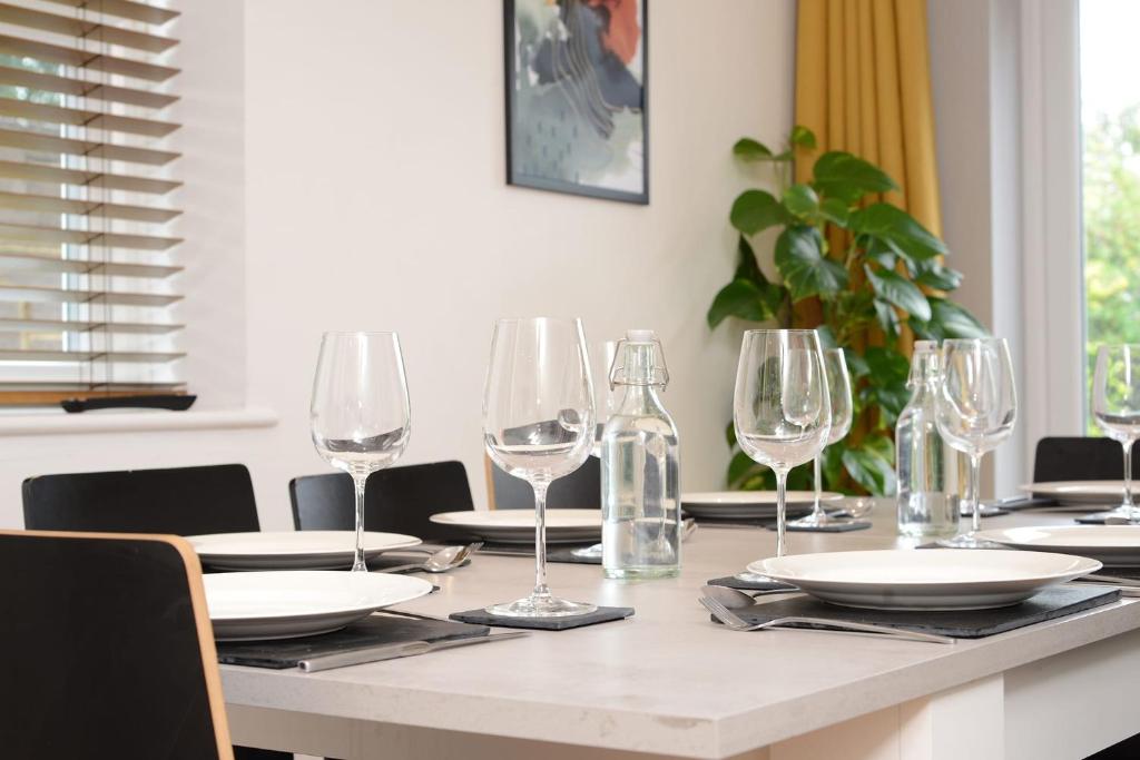 un tavolo con bicchieri da vino e piatti di Stylish and spacious Southampton stay a Southampton