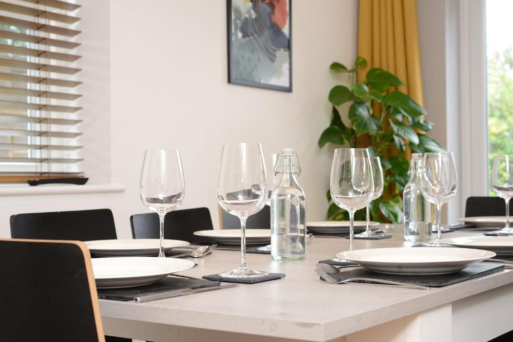 a table with wine glasses and plates on it at Stylish and spacious Southampton stay in Southampton