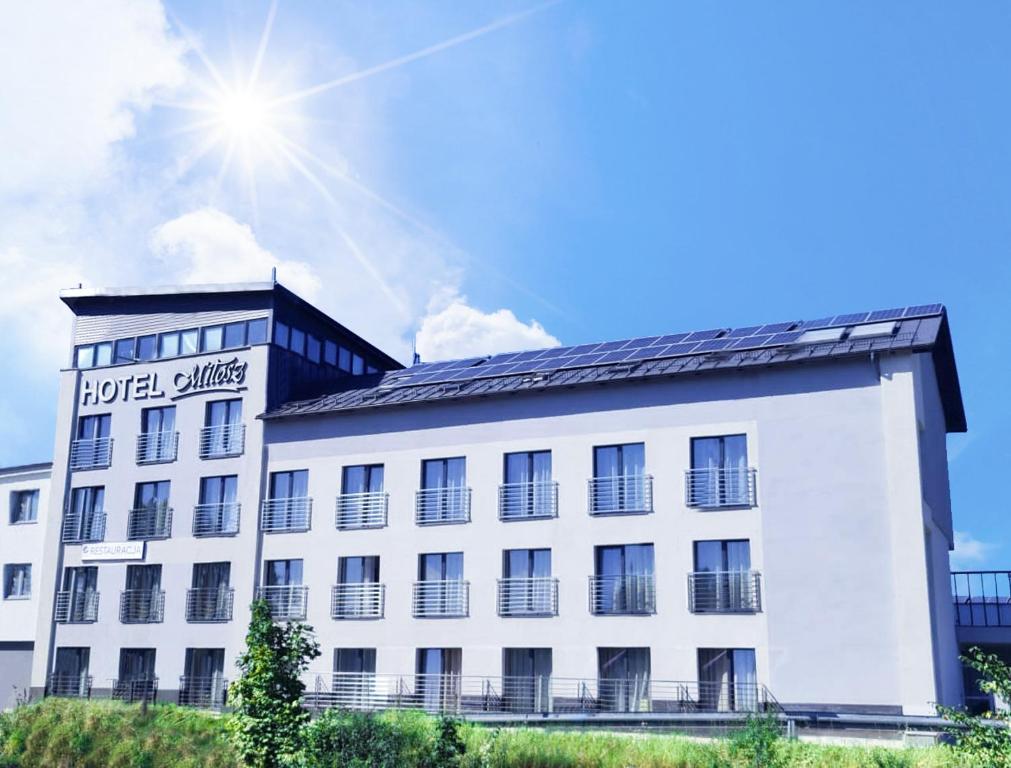 a large white building with the sun in the sky at Hotel Miłosz Restauracja, Basen dla dzieci, Sala Zabaw, Siłownia in Kartuzy