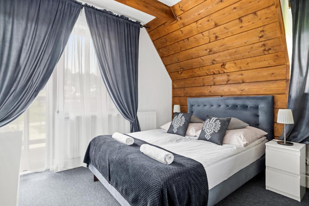 um quarto com uma cama grande e um tecto em madeira em Villa 307 Spisz Resort em Jurgów