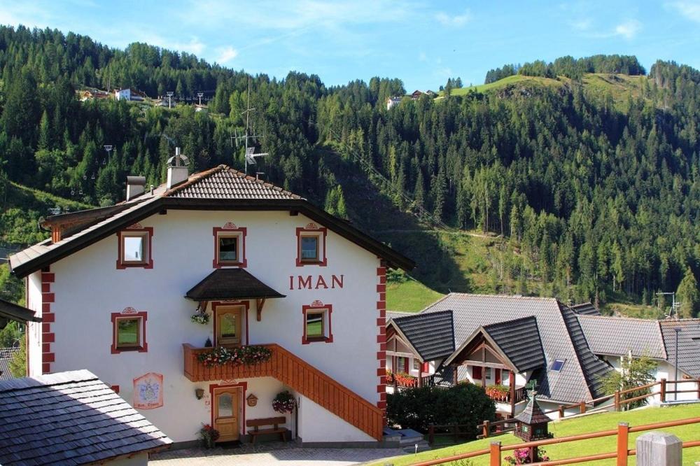 een gebouw in een dorp met een berg op de achtergrond bij Bed and Breakfast Iman in Santa Cristina in Val Gardena