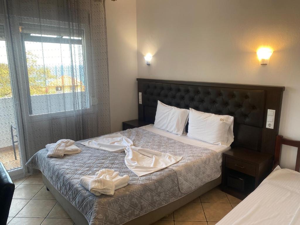a bedroom with a bed with towels on it at Blue Bay Beach Hotel in Koinyra