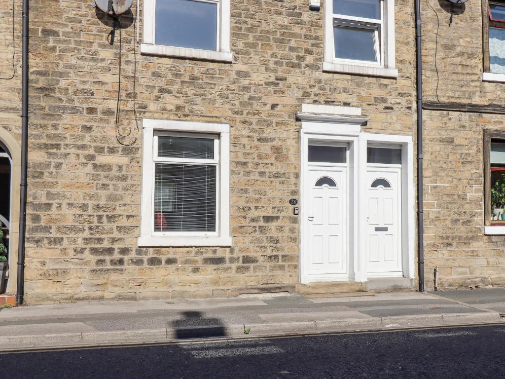 a brick building with white doors on a street at 28 Water Street in Skipton