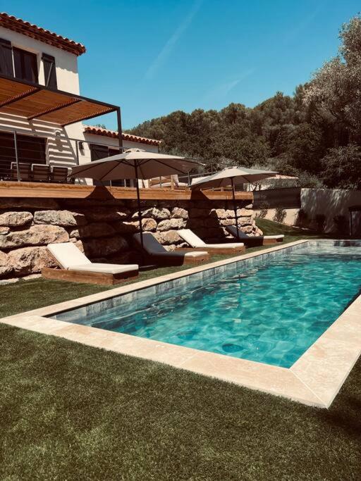 - une piscine avec des chaises et des parasols à côté d'une maison dans l'établissement Villa Azur, à La Valette-du-Var