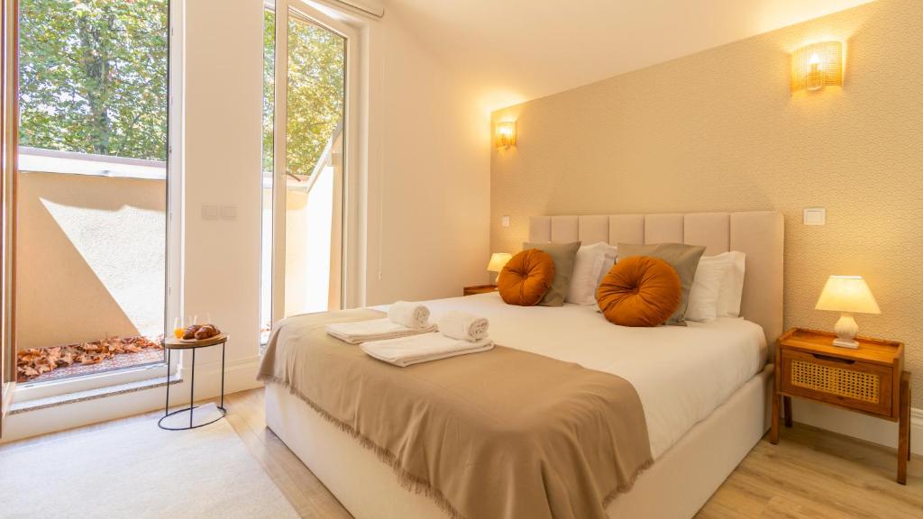 um quarto com uma cama com almofadas laranja e uma janela em Urban House Marquês by LovelyStay em Porto