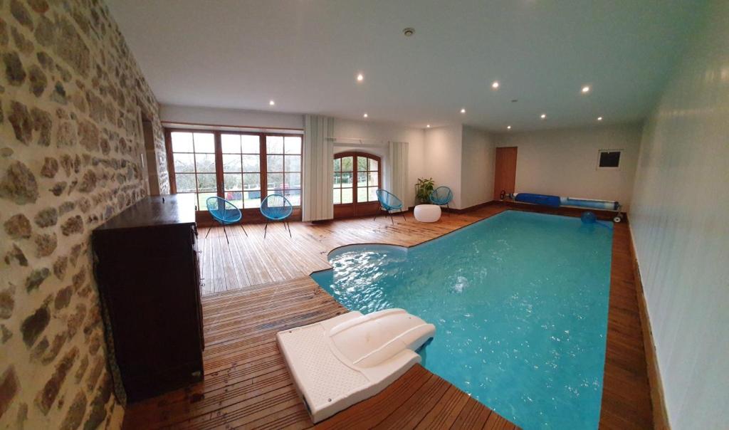 una gran piscina con sillas en una habitación en Gîte Auverg'Nature, en Espinasse