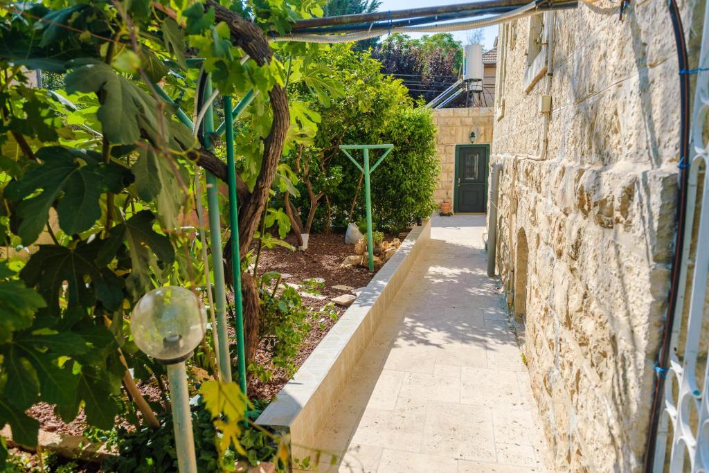 um beco num jardim ao lado de uma parede de pedra em Crown Solomon em Jerusalém