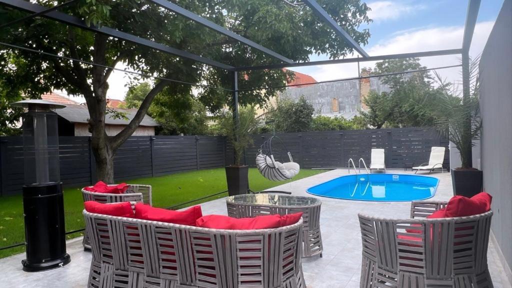 a patio with chairs and a pool in a yard at Casa Di David in Buzău