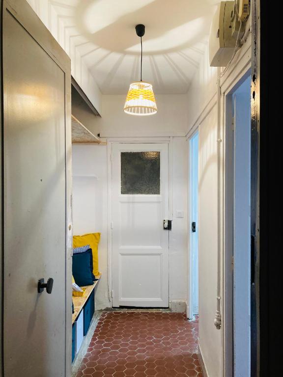 a hallway with a white door and a chandelier at Pied à terre Méditerranéen ! in Marseille