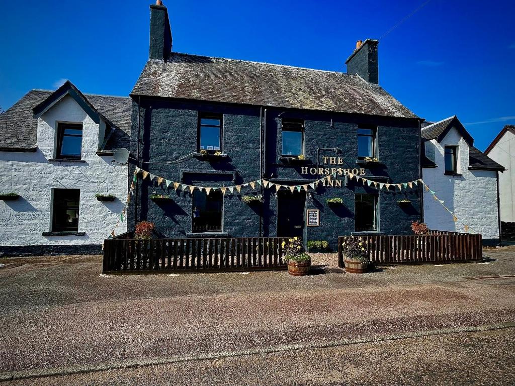 un edificio con un cartel que lee la posada de las amas de casa en The Horseshoe, en Lochgilphead