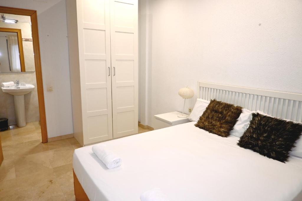 - une chambre blanche avec un lit et un lavabo dans l'établissement Homenfun Barcelona Sagrada Familia Lepanto, à Barcelone