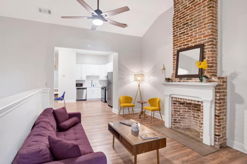 a living room with a purple couch and a fireplace at Stars on State in the Heart of Downtown Historic District in Mobile