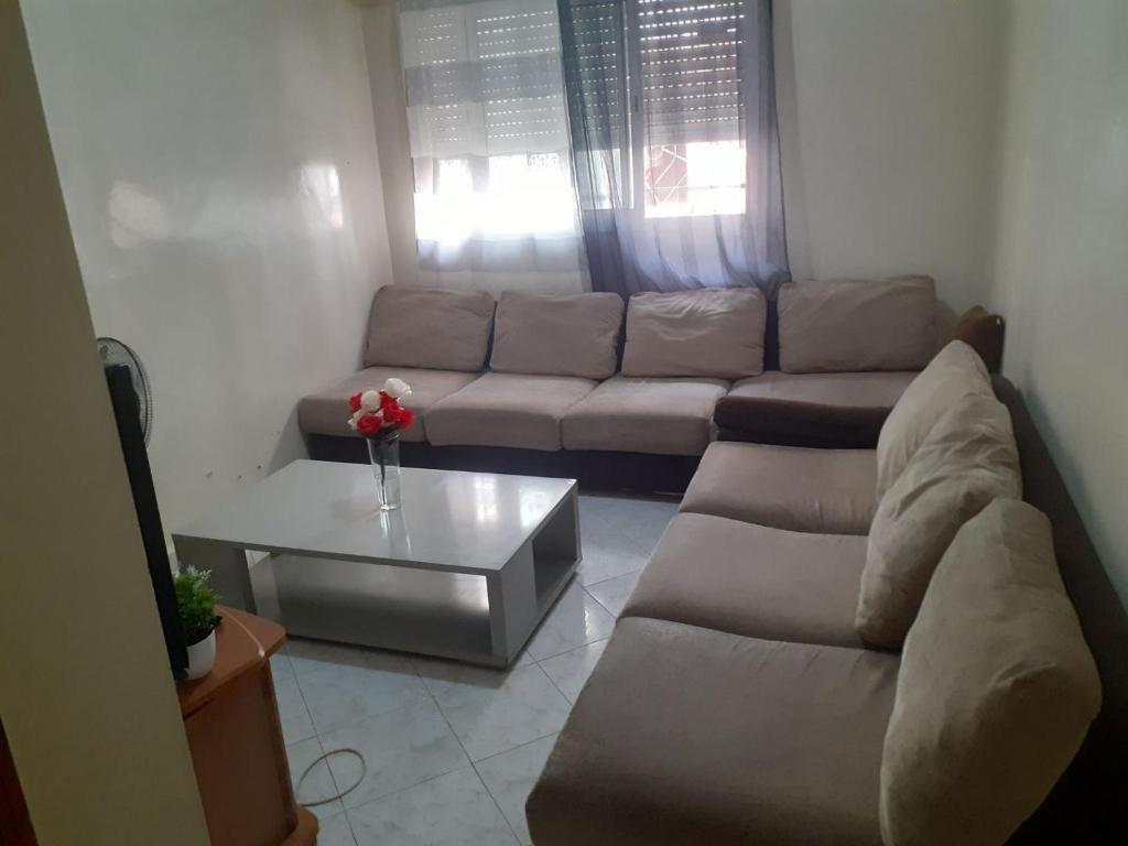 a living room with a couch and a coffee table at Appartement Sidi Maarouf in Casablanca