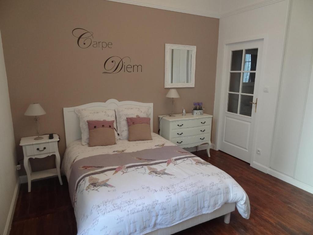 a bedroom with a bed and a sign on the wall at Studio Maison Fyot in Dijon