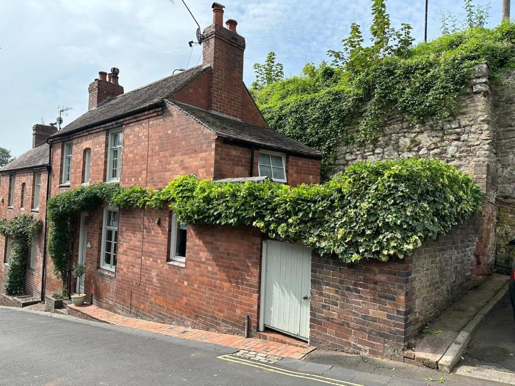 a brick house with ivy growing on the side of it at The Railway Cottage Bridgnorth in Bridgnorth