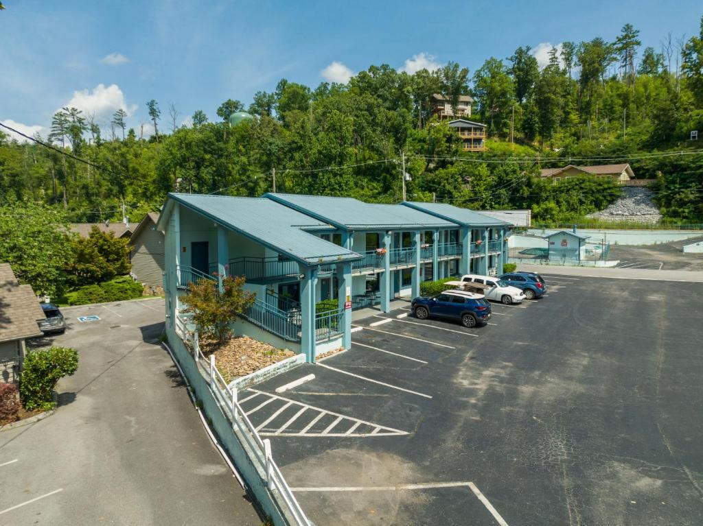 a parking lot with a blue building with cars in it at Country Town N' Suites in Gatlinburg