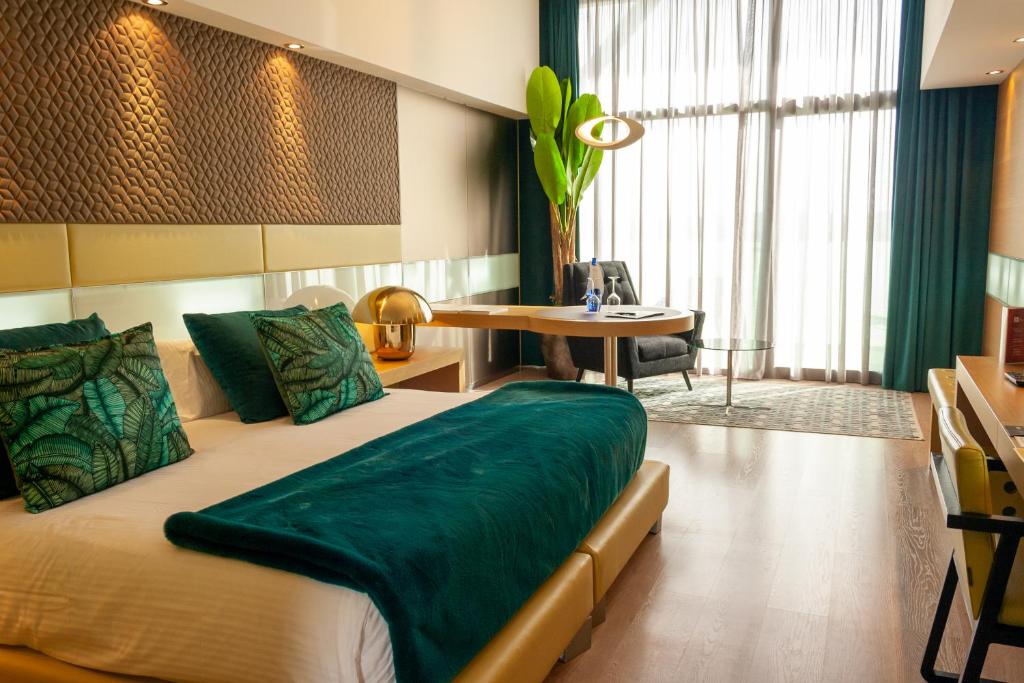 Un dormitorio con una cama con una manta verde. en La Finca Resort, en Algorfa