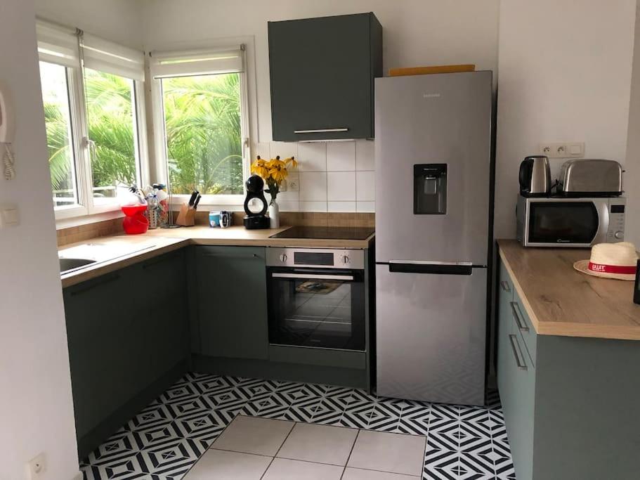 a kitchen with a refrigerator and a stove top oven at A deux pas du port, jolie maison redécorée in La Teste-de-Buch
