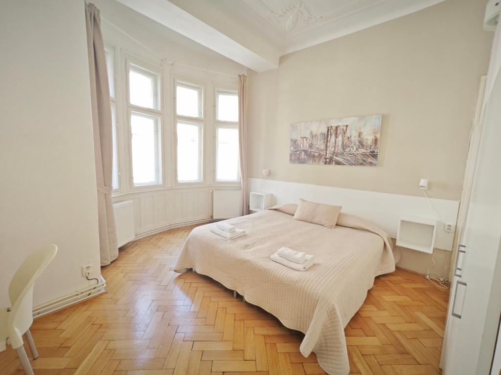 1 dormitorio blanco con 1 cama con 2 toallas en Vincanto Apartments, en Praga