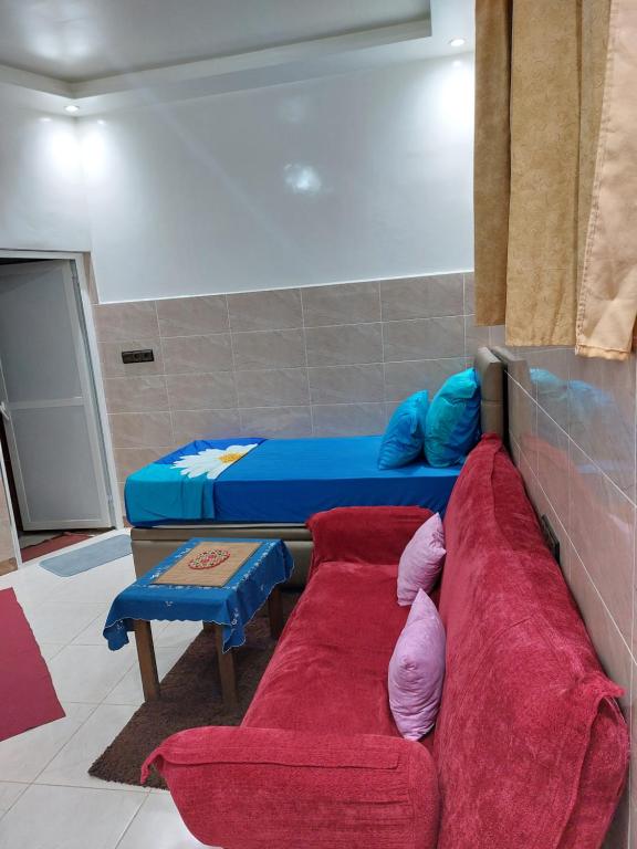 ein Wohnzimmer mit einem Sofa und einem Bett in der Unterkunft Garden Beet in Sidi Rahal