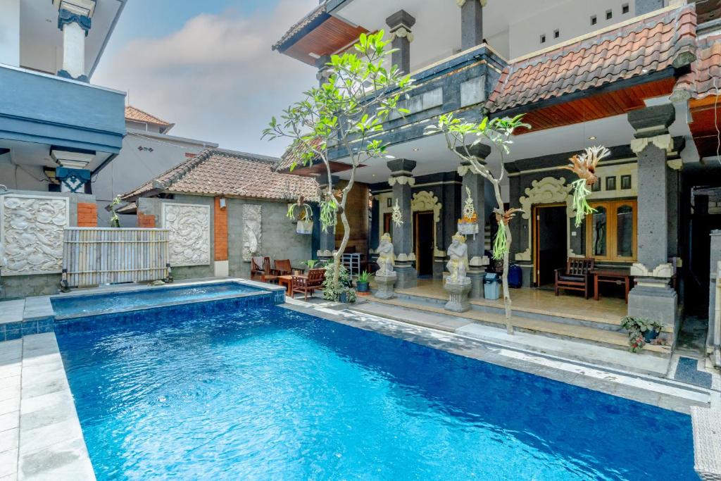 a swimming pool in front of a house at Suarsena Ubud in Ubud