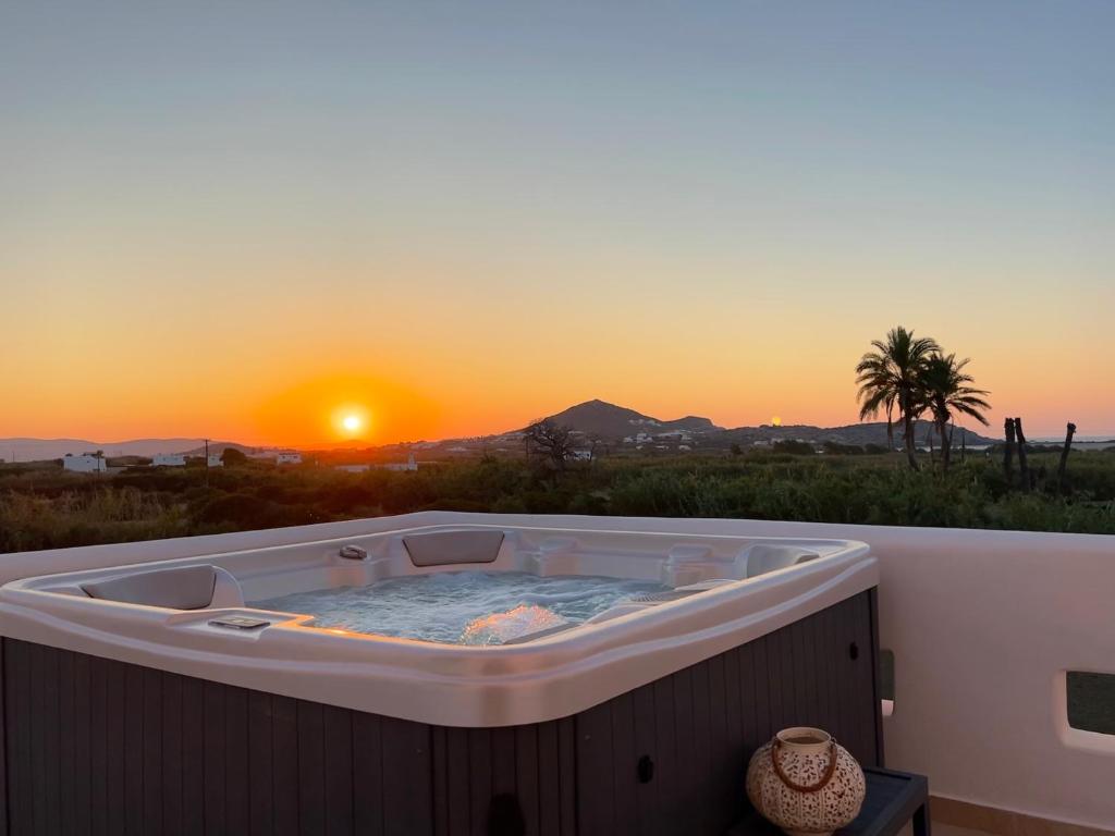 a hot tub with the sunset in the background at Villa vaya in Naxos Chora
