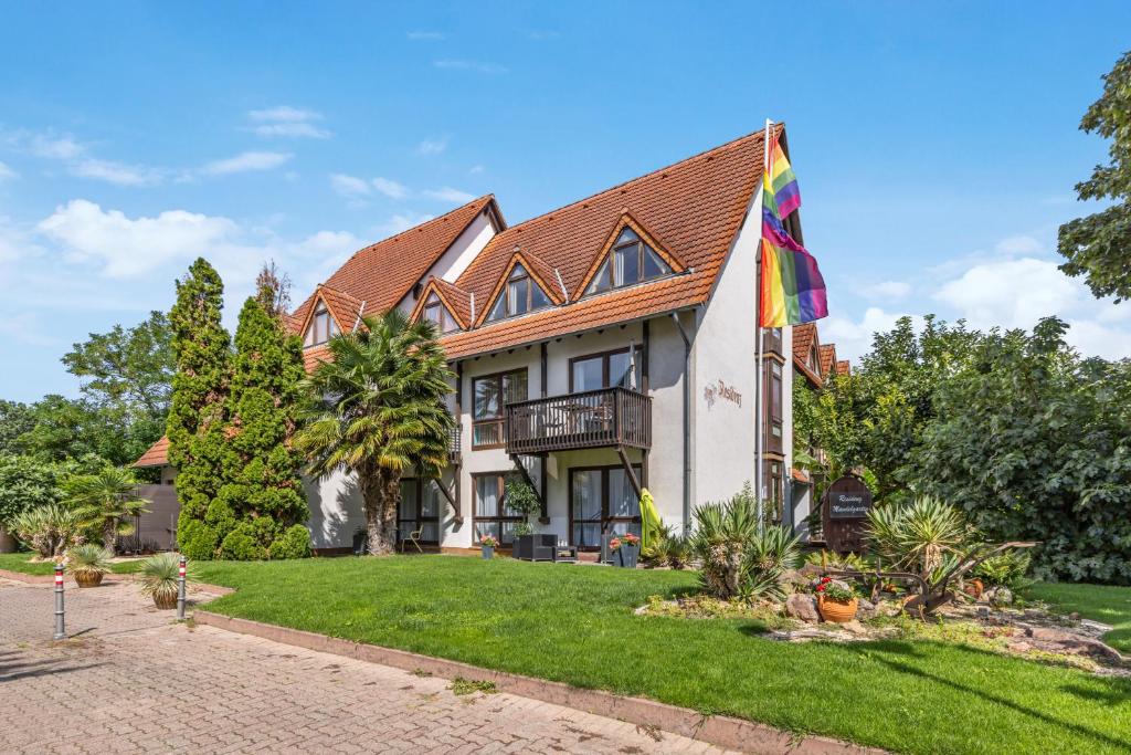a house with a flag on the lawn at Belisima Apartments I Ferienwohnungen Deidesheim I Deutsche Weinstraße I Individuell mit Charm I Ruhig am Kurpark I Nähe Supermarkt - Bäcker - Bahnhof in Deidesheim