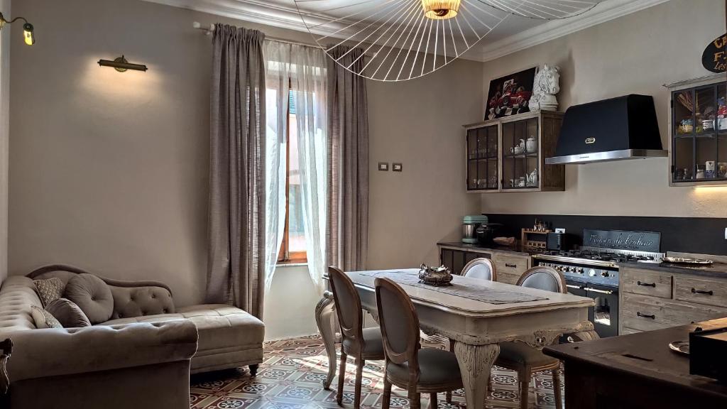 un soggiorno con tavolo e divano e una cucina di Residenza d'Epoca CAVALIERE a Bibbona
