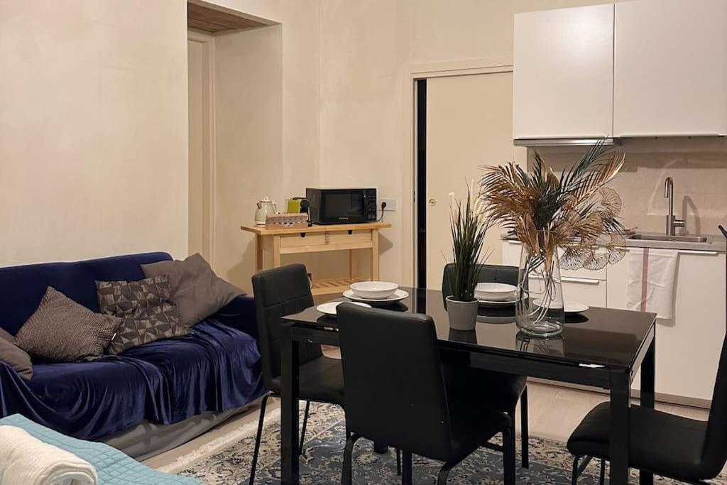 sala de estar con mesa y sofá azul en Raphael Temporary Home in Urbino en Urbino