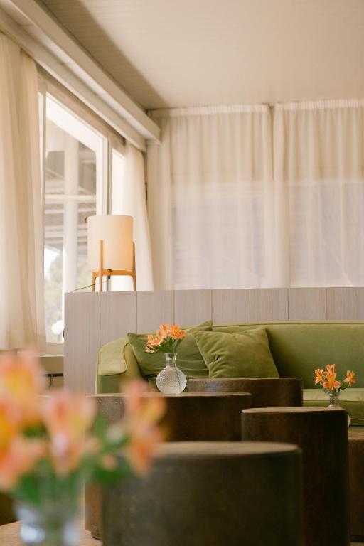 a living room with a green couch and a window at Hotel Santa Marta in Lloret de Mar