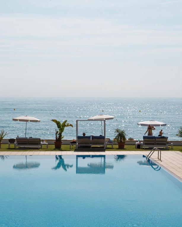 a swimming pool with a view of the ocean at Hotel Santa Marta in Lloret de Mar