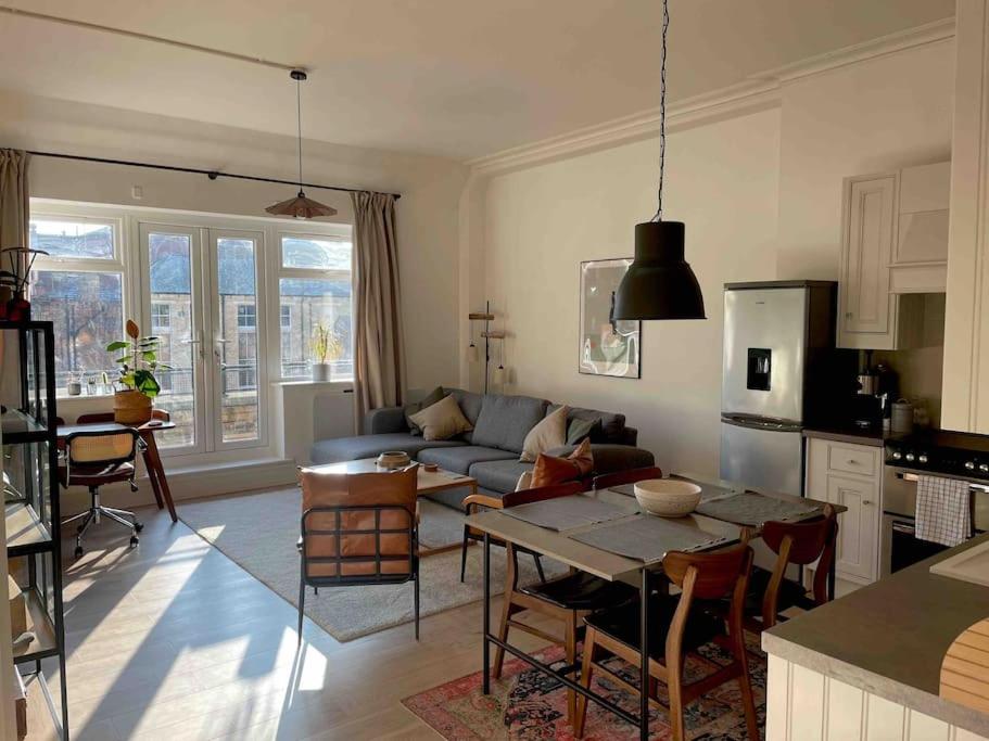 ein Wohnzimmer mit einem Sofa und einem Tisch in der Unterkunft Stylish city-centre apartment with balcony in Liverpool