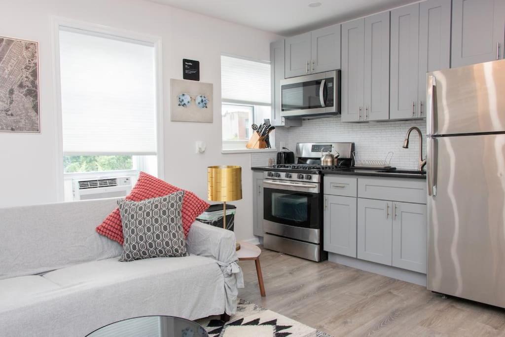 a living room with a couch and a kitchen at Modern 1BR Exclusive Space in Historic Brooklyn in Brooklyn