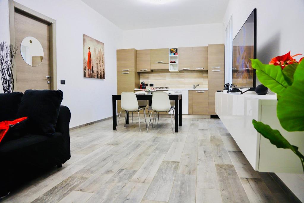a living room with a table and chairs and a kitchen at CASA CON GIARDINO NETFLIX E SERVIZIO RISTORAZIONE - 10 minuti da Torino in Volvera