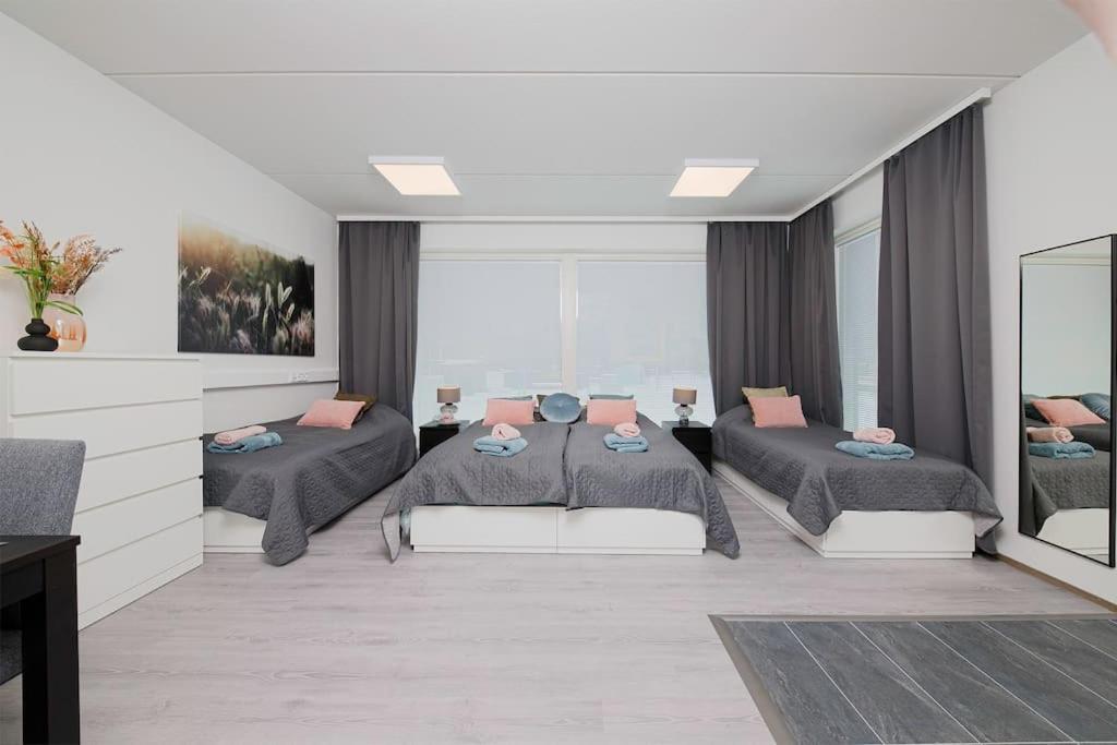 Un dormitorio con dos camas y una sala de estar. en Casa Amare Tampere, en Tampere