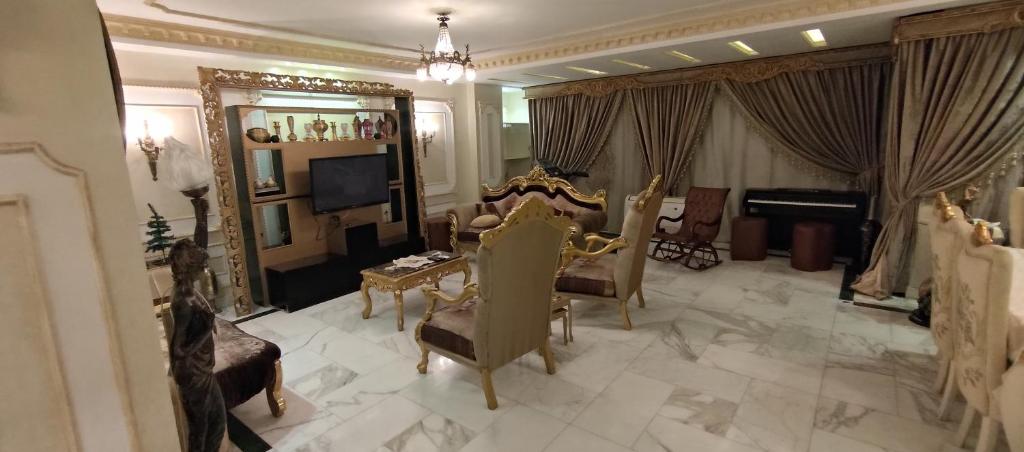 un salon avec un canapé, des fauteuils et une télévision dans l'établissement Maadi Shaya, au Caire